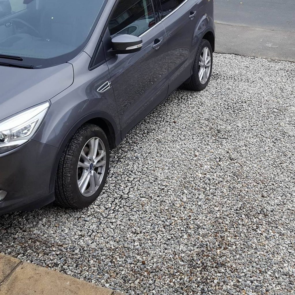 Fresh decorative gravel retained in X-Grid cells on a domestic driveway